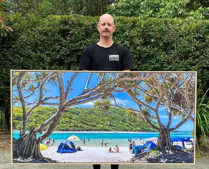 A Guy Holding A Panoramic Picture In A Frame