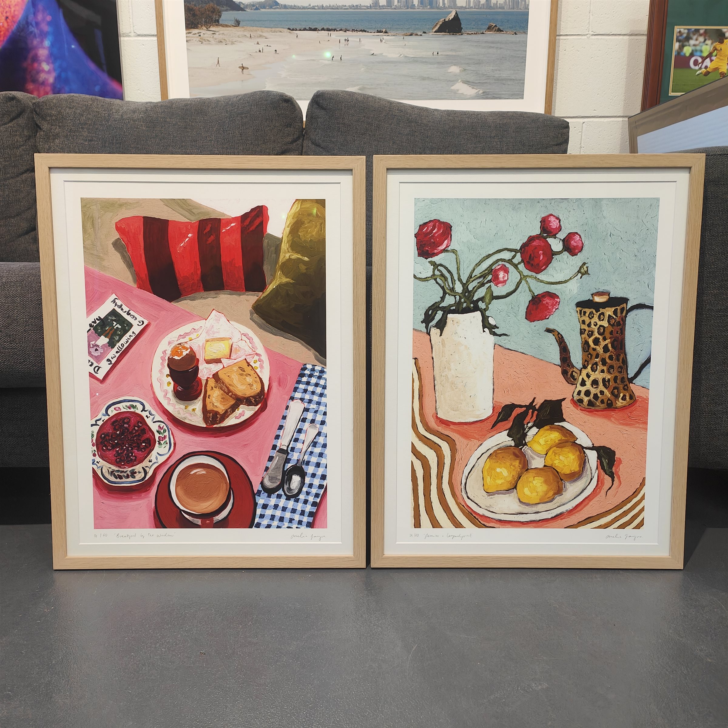 Two signed art prints in light timber frames with white mats