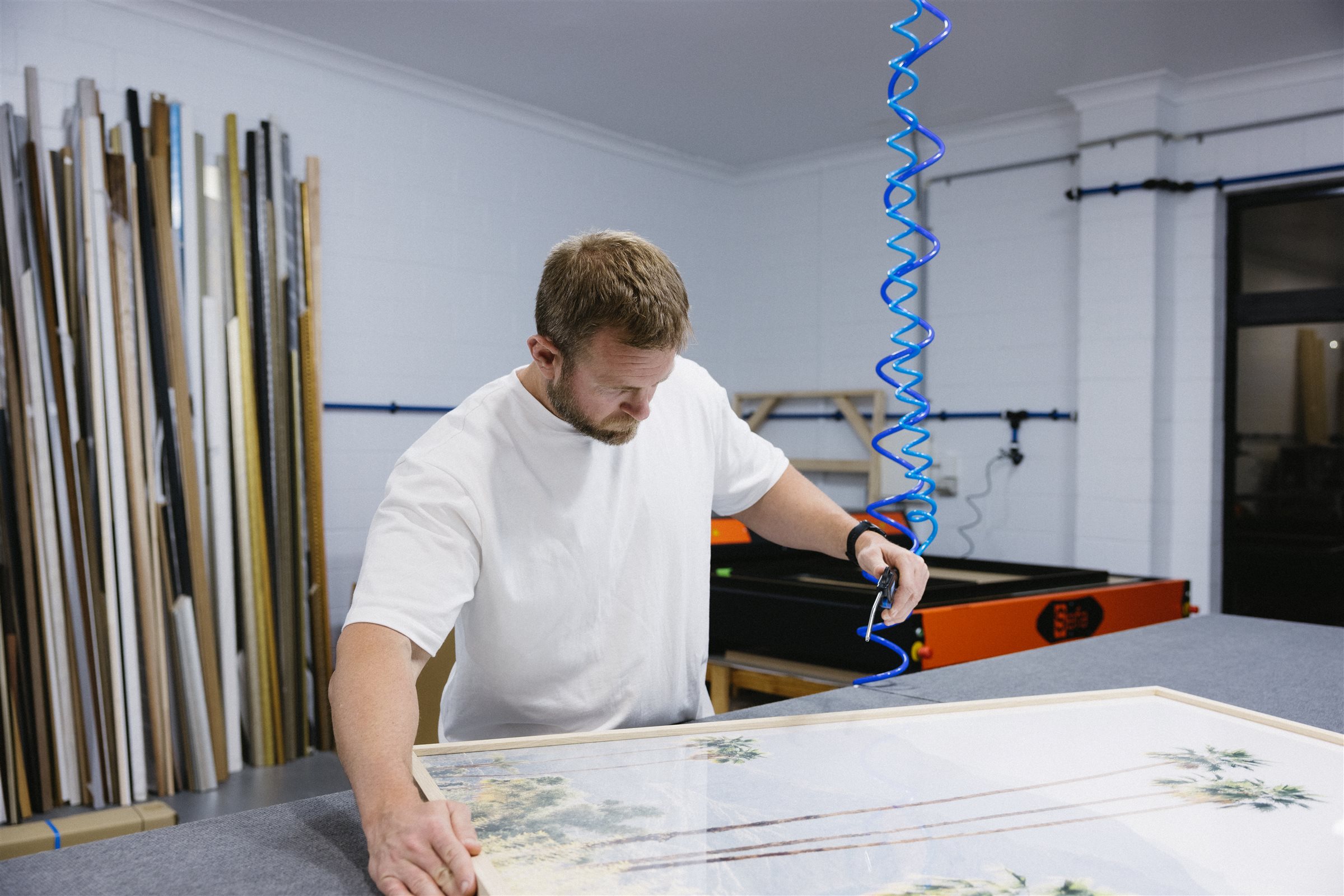 Framer checking a large framed artwork in the Burleigh Heads framing workshop